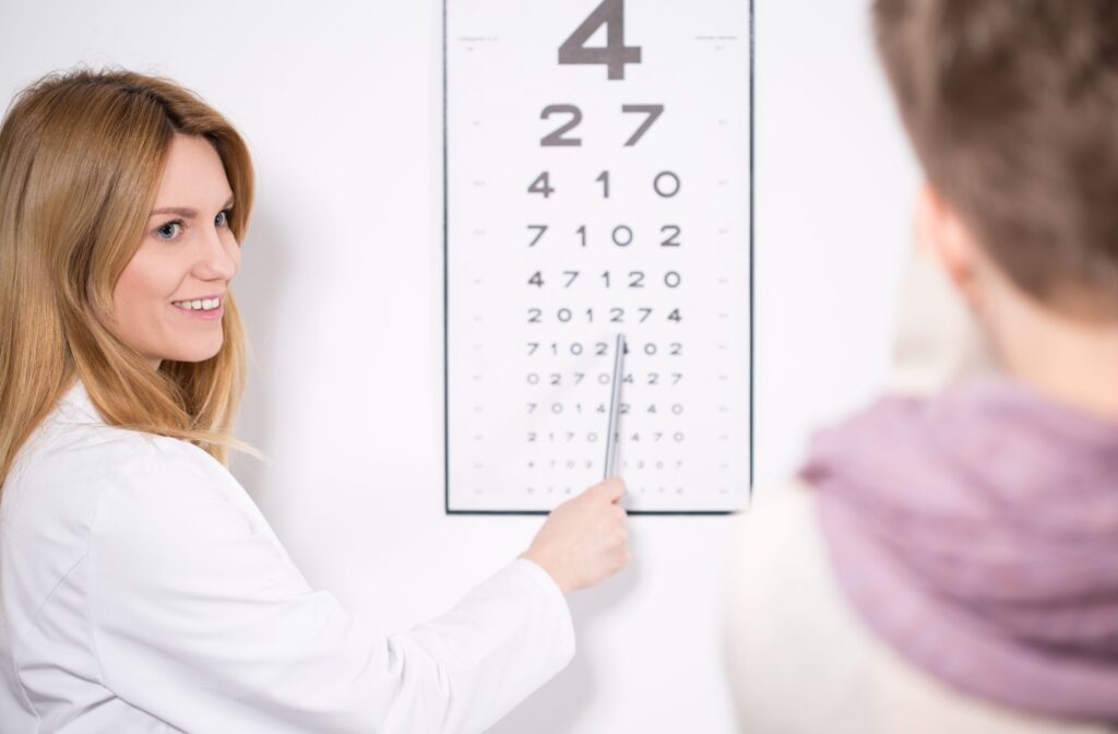 An eye doctor directs their patients attention to the Snellen Eye Chart to check their visual clarity.