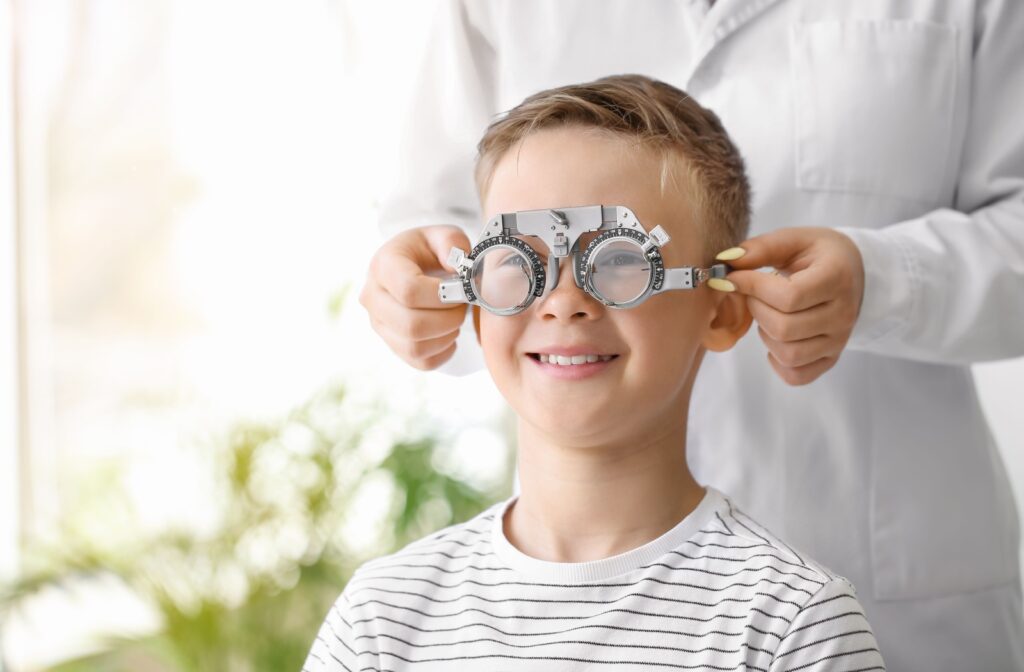 A child getting a vision test with trial frames during an eye exam.