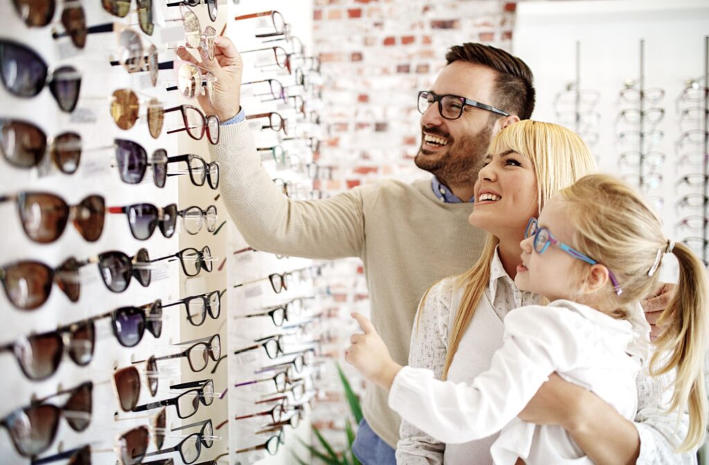 A family looks through a wide range of glasses styles available at their optometrist while picking glasses for their child