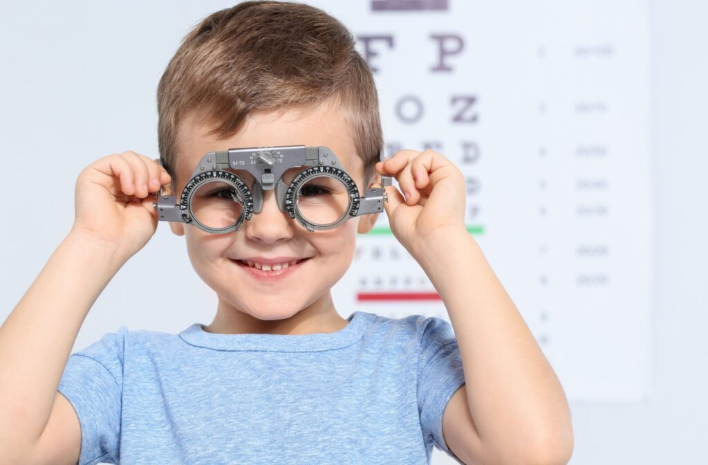 Child wearing a phoropter in front of vision chart.
